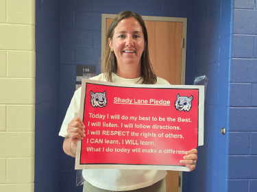 teacher holding a red sign
